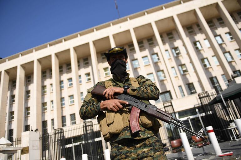 Un rebelde armado hace guardia en una calle de Damasco, Siria.