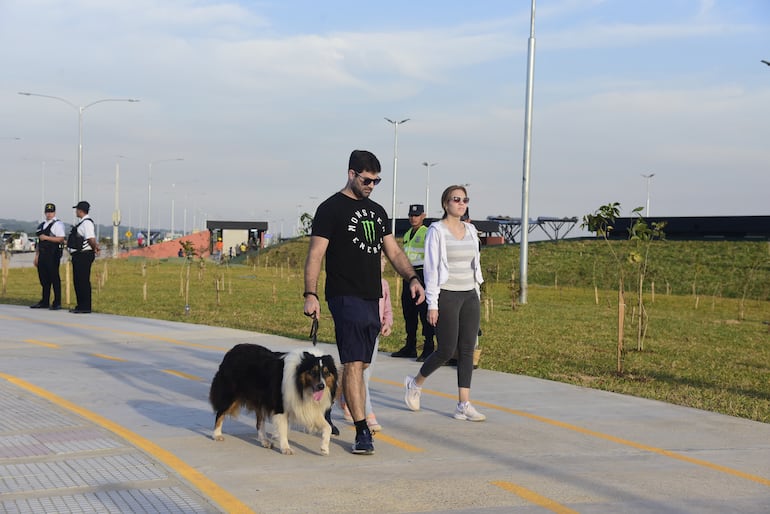 Una pareja pasea a su perro en la Costanera Sur.