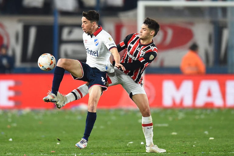 El paraguayo Damián Bobadilla (d), jugador del Sao Paulo, pelea por el balón en el partido frente a Nacional por la ida de los octavos de final de la Copa Libertadores 2024 en el estadio Gran Parque Central, en Montevideo, Uruguay. 