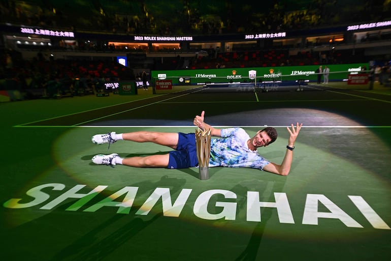 Tirado en la pista central del Master 1000 de Shanghai, el polaco Hubert Hurkacz posa con el trofeo de campeón luego de vencer en una apasionante final al ruso Andrev Rubkev. Ambos tuvieron la posibilidad de ganar el partido final.