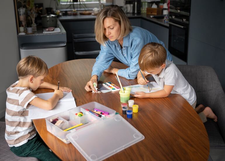 Madre ayudando a sus hijos con las tareas escolares.