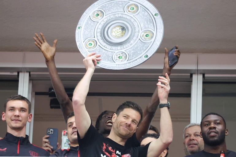 Leverkusen (Germany), 14/04/2024.- Leverkusen's head coach Xabi Alonso lifts a mock Bundesliga Meisterschale trophy, celebrating the German Bundesliga championship with his team after the German Bundesliga soccer match between Bayer 04 Leverkusen and SV Werder Bremen in Leverkusen, Germany, 14 April 2024. (Alemania) EFE/EPA/CHRISTOPHER NEUNDORF CONDITIONS - ATTENTION: The DFL regulations prohibit any use of photographs as image sequences and/or quasi-video.
