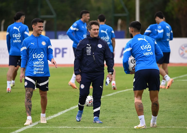 Matías Rojas (i) y Omar Alderete (d) conversan con Guillermo Barros Schelotto en el entrenamiento de la selección paraguaya en el Centro de Alto Rendimiento, en Yapné. 