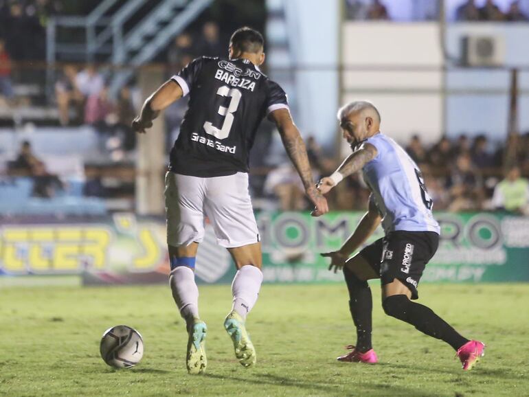 El argentino Alexander Barboza, defensor de Libertad, pelea el balón con José Ariel Núñez, delantero de Guaireña, en el partido por la décimo octava jornada del torneo Apertura 2023 del fútbol paraguayo en el estadio Parque del Guairá, en Villarrica.