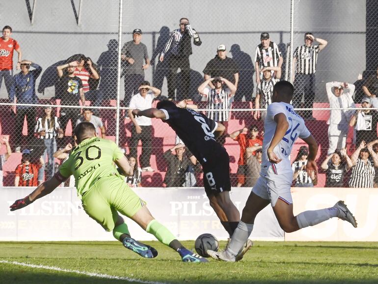 El argentino Bautista Merlini (c), futbolista de Libertad, pelea por el balón frente a Santiago Rojas y Jordan Santacruz, jugadores de Nacional, en un partido del fútbol paraguayo en el estadio Arsenio Erico, en Asunción.