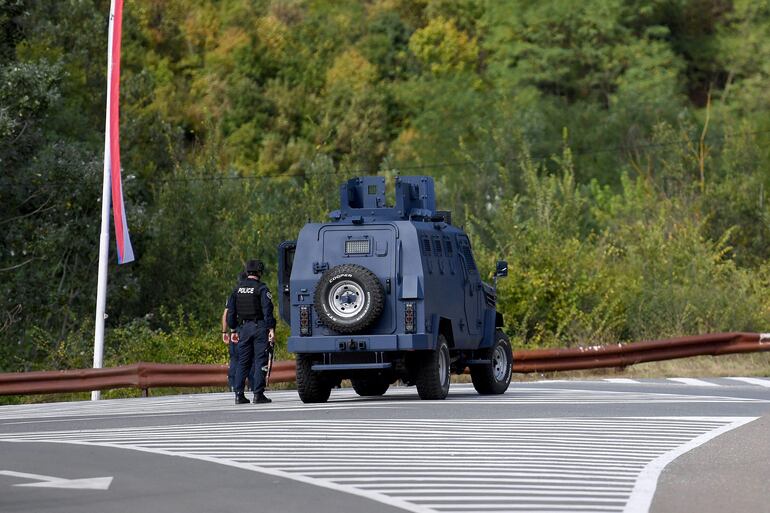 Los agentes de policía de Kosovo hacen guardia en la entrada de la aldea de Banjska el 24 de septiembre de 2023, después de que un policía muriera y otro resultara herido en el norte de Kosovo la madrugada del domingo. Según las autoridades, el incidente se produjo durante un ataque armado a una patrulla policial cuando se acercaba a una carretera bloqueada cerca de la frontera con Serbia. (Foto. STRINGER / AFP)