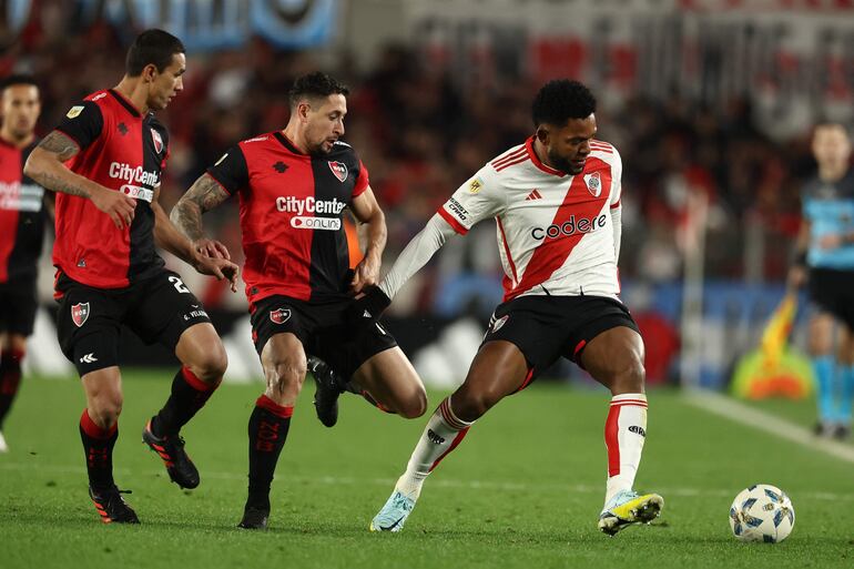 River Plate's Colombian forward Miguel Borja (R) and Newells Old Boy's defender Armando Mendez (C) fight for the ball during the Argentine Professional Football League Tournament 2024 'Cesar Luis Menotti' match between River Plate and Newells Old Boys at Mas Monumental stadium in Buenos Aires on August 25, 2024. (Photo by ALEJANDRO PAGNI / AFP)