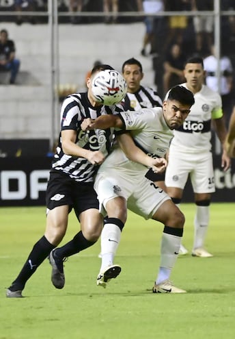 El extremo franjeado Rodney Redes (24 años)  intenta imponer el físico ante la presión del volante Hernesto Caballero (32). Luis  Carlos Cardozo (35)  y Derlis González (30) observan la acción en el fondo.