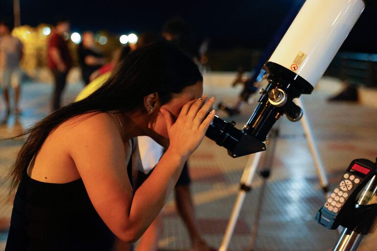 Una mujer observa por un telescopio el eclipse lunar parcial este martes, en Asunción (Paraguay). 