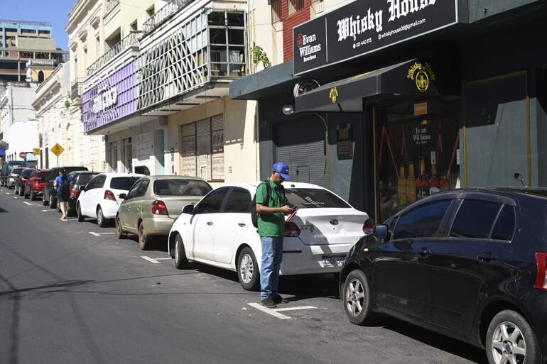 Un funcionario de Parxin verifica vehículos estacionados en una zona tarifada del microcentro de Asunción, el pasado jueves.