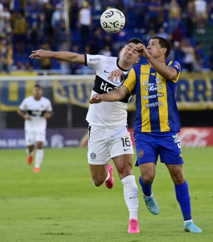 José Leguizamón disputa la pelota con el delantero de Olimpia Guillermo Paiva.