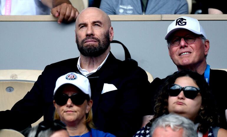 John Travolta observa a Carlos Alcaraz de España en acción contra Novak Djokovic de Serbia durante el partido por la medalla de oro masculina individual de las competiciones de tenis de los Juegos Olímpicos de París 2024, en Roland Garros en París, Francia.