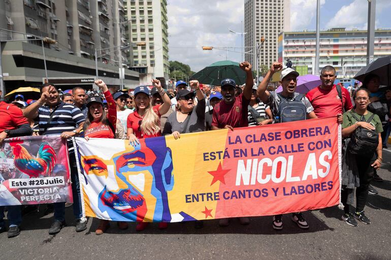 AME2565. CARACAS (VENEZUELA), 22/08/2024.- Simpatizantes del Gobierno del presidente de Venezuela, Nicolás Maduro, participan en una marcha de apoyo a la 'Ley contra el odio y el fascismo' este jueves, en Caracas (Venezuela).Cientos de chavistas se movilizaron este jueves en Caracas, hasta la sede de la Asamblea Nacional (AN, Parlamento), para dar su respaldo a un proyecto de 'ley contra el fascismo, neofascismo y expresiones similares', actualmente en desarrollo, y que el mandatario Nicolás Maduro pidió que se apruebe "muy rápido". EFE/ Ronald Peña R.
