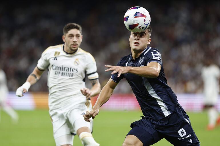 MADRID, 17/09/2023.- El centrocampista escocés de la Real Sociedad, Kieran Tierney (d), con el balón ante el centrocampista uruguayo del Real Madrid, Fede Valverde, durante el encuentro correspondiente a la quinta jornada de primera división disputado hoy domingo en el estadio Santiago Bernabéu, en Madrid. EFE / Rodrigo Jiménez.
