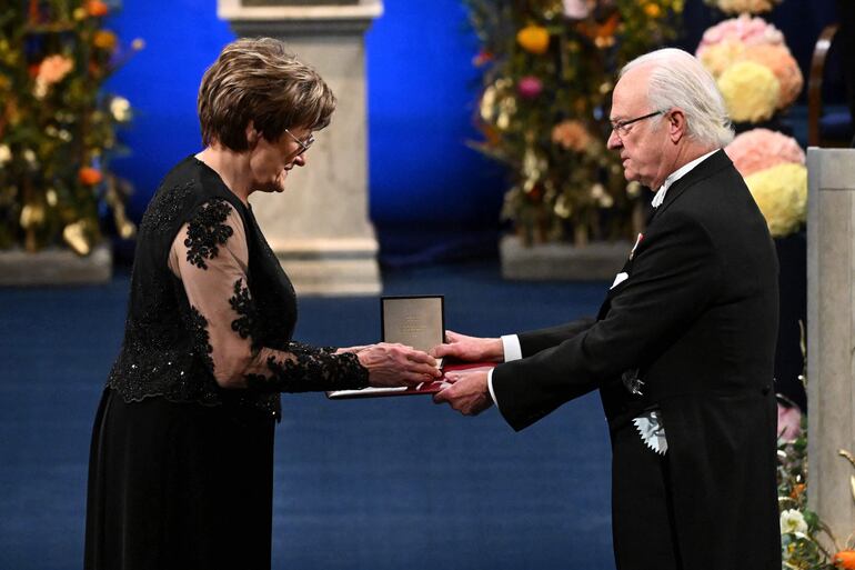 La laureada bioquímica húngaro-estadounidense Katalin Kariko (izq.) recibe el Premio Nobel de Fisiología o Medicina 2023 de manos del rey Carlos XVI Gustavo de Suecia durante la ceremonia de entrega de premios Nobel en la Sala de Conciertos de Estocolmo, Suecia.