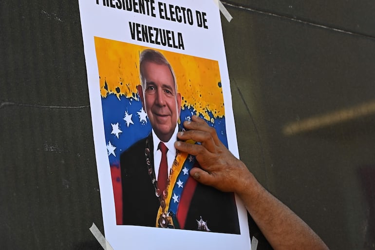 Una persona pega un cartel durante una concentración en la plaza Simón Bolívar en la ciudad de Montevideo (Uruguay). 