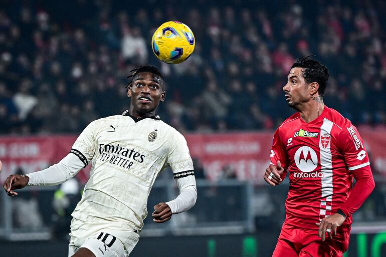 AC Milan's Portuguese forward #10 Rafael Leao and Monzas Italian defender #4 Armando Izzo fights for the ball during the Italian Serie A football match between AC Monza and AC Milan at the Brianteo stadium in Monza, on February 18, 2024. (Photo by Piero CRUCIATTI / AFP)