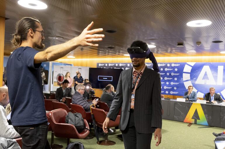 Un voluntario prueba las "lumenglasses", un par de gafas que imitan las mismas características que un perro guía, durante la exhibición de exoesqueletos controlados mentalmente y otras tecnologías de interfaz cerebro-máquina impulsadas por IA.