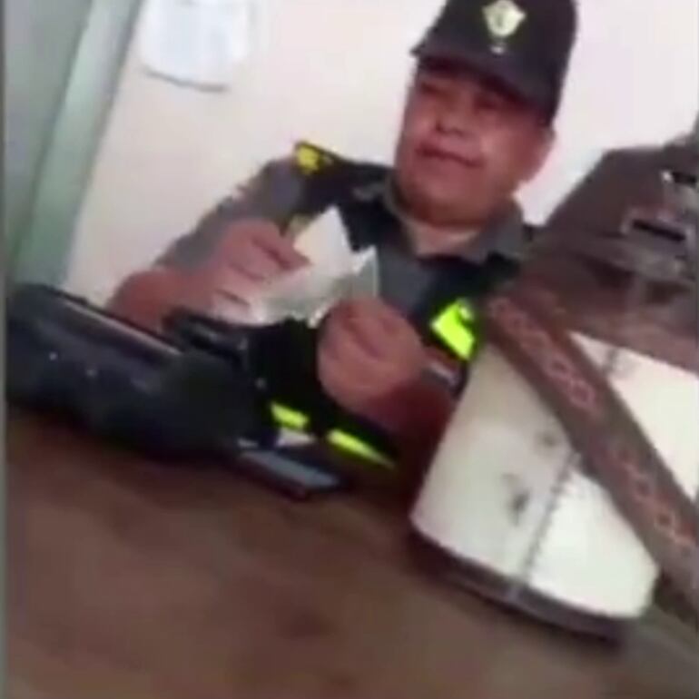 Captura del video donde la agente agarrando el dinero de la coima.