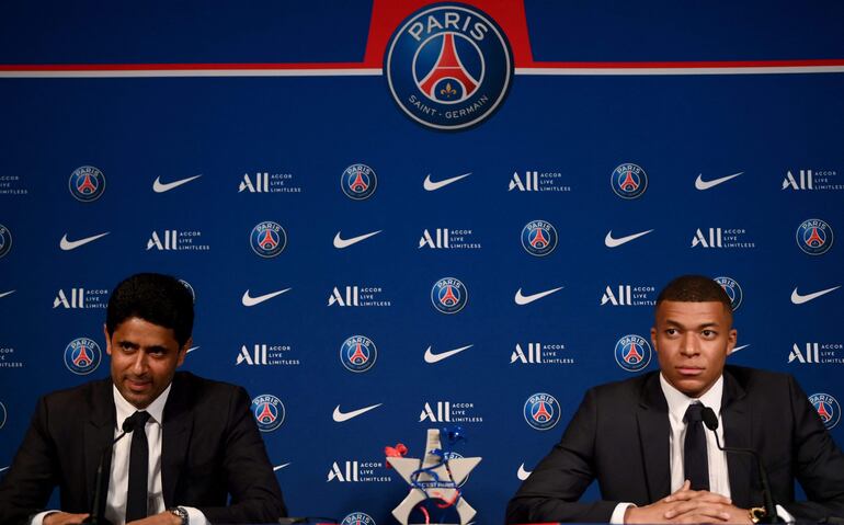 (FILES) Paris Saint-Germain's CEO Nasser Al-Khelaifi (L) and French forward Kylian Mbappe (R) give a press conference at the Parc des Princes stadium in Paris on May 23, 2022, two days after the club won the Ligue 1 title for a record-equalling tenth time and its superstar striker Mbappe chose to sign a new contract until 2025 at PSG rather than join Real Madrid. France's Professional Football League (LFP) joint committee will rule on October 25, 2024 on the dispute between Mbappe and PSG. (Photo by FRANCK FIFE / AFP)