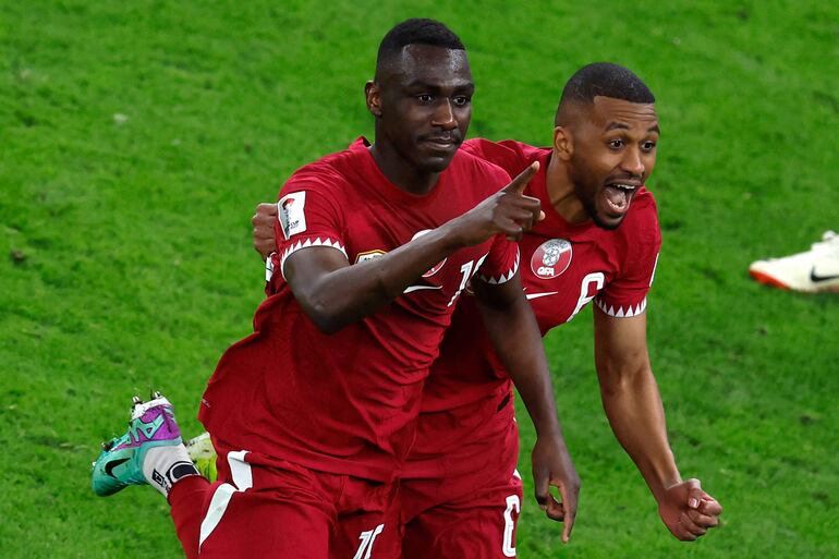 Qatar's forward #19 Almoez Ali (L) celebrates scoring his team's third goal during the Qatar 2023 AFC Asian Cup semi-final football match between Iran and Qatar at al-Thumama Stadium in Doha on February 7, 2024. (Photo by KARIM JAAFAR / AFP)