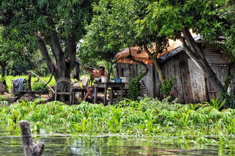 Un poblador de Puerto Carrizal, en Atingy, saluda desde su vivienda totalmente rodeada de agua.