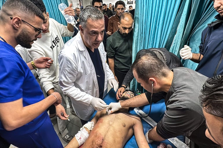 El Dr. Husam Abu Safiya, director del Hospital Kamal Adwan, supervisa la curación de un herido en un bombardeo israelí, noviembre de 2024 (AFP)