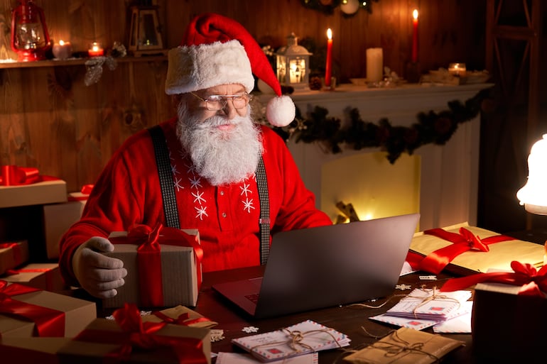 Imagen ilustrativa: un Papá Noel con una computadora.