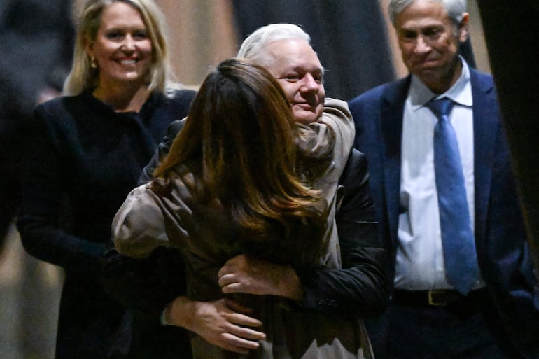 Julian Assange abraza a su esposa Stella al momento de su llegada al aeropuerto de Canberra, Australia, este miércoles.