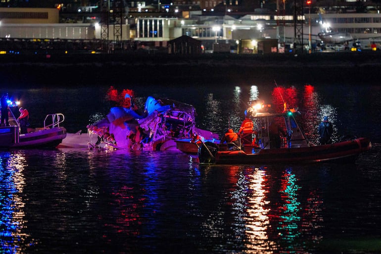 Rescatistas trabajan en la madrugada de este jueves en el sitio de la caída del avión en el río Potomac, en Washington.