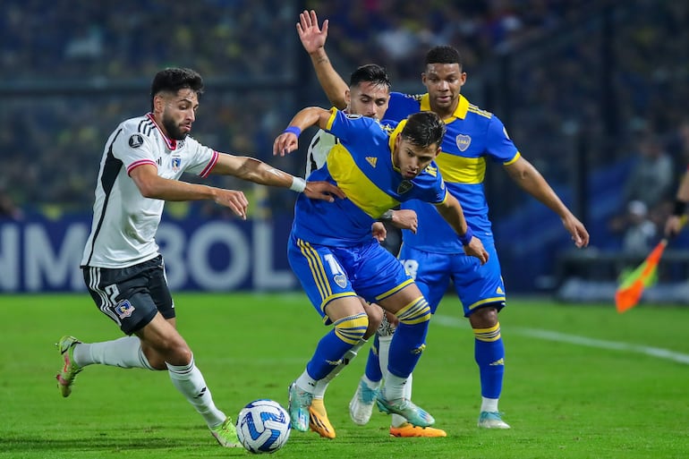 El paraguayo Óscar Romero (d), futbolista de Boca Juniors, disputa un balón con Jeyson Rojas, de Colo Colo, en un partido de la fase de grupos de la Copa Libertadores en el estadio La Bombonera, en Buenos Aires, Argentina.