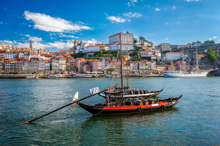 Vista de la ciudad de Oporto y el río Duero con barcos tradicionales con barriles de vino de Oporto y barco de vela desde el famoso mirador turístico Marginal de Gaia. Porto, Vila Nova de Gaia, Portugal.