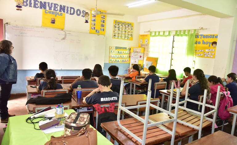 Niños rezan antes del almuerzo en una sala de clases de la escuela Talavera Richer.