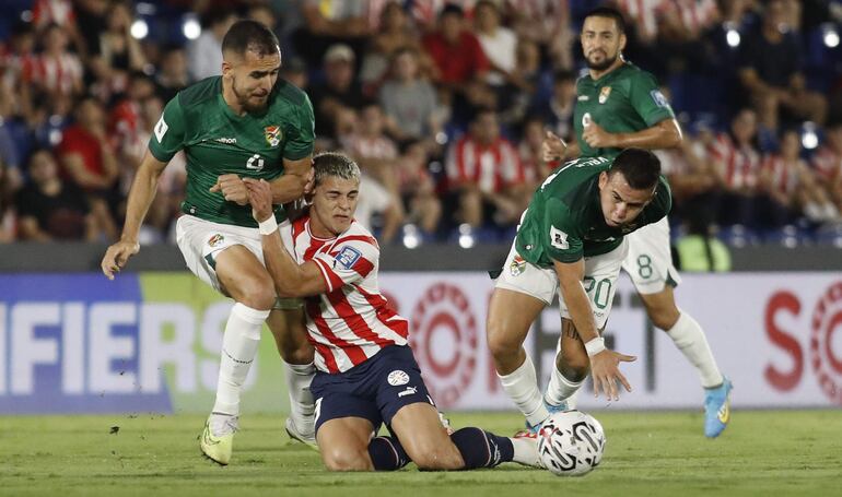 Ramón Sosa (c), jugador de la selección paraguaya, disputa el balón con Luis Haquín (i), futbolista de Bolivia, en un partido de las Eliminatorias Sudamericanas 2026 en el estadio Defensores del Chaco, en Asunción, Paraguay.
