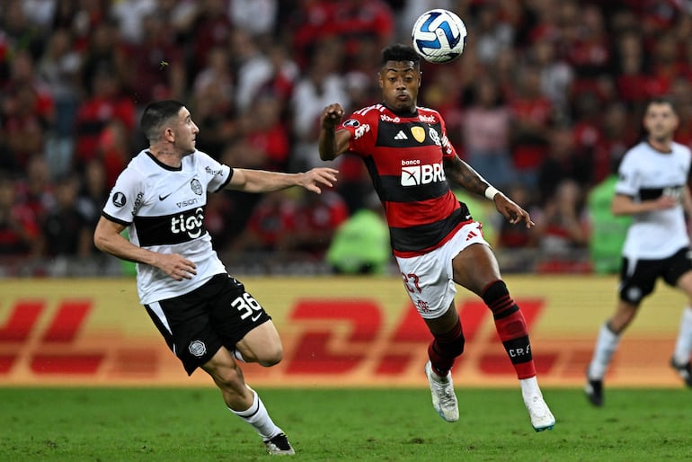 El uruguayo Facundo Zabala (i), futbolista de Olimpia, pelea por el balón junto a Bruno Henrique, futbolista de Flamengo, en el partido de ida de los octavos de final de la Copa Libertadores en el estadio Maracaná, en Río de Janeiro, Brasil.