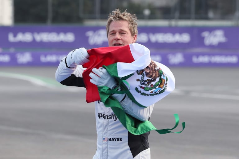 El actor estadounidense Brad Pitt ondea una bandera de México frente a sus seguidores en el Autódromo de los Hermanos Rodríguez en Ciudad de México (México). (EFE/ Mario Guzmán)
