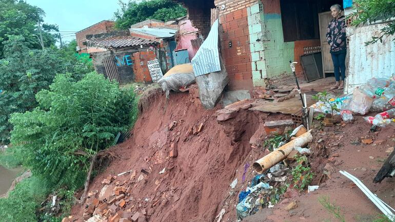 Lidia Ferreira mira con angustia como la erosión avanza hacia su terreno, su casa está a punto de caer al arroyo Fortín de Villa Elisa.