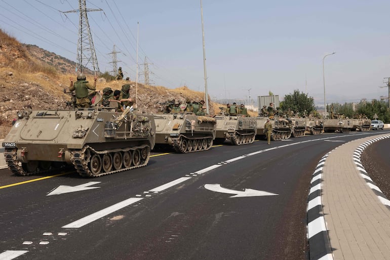 Soldados israelíes en tanques de guerra recorren una calle en Kiryat Shmona cerca de la frontera con el Líbano.