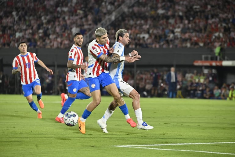 Julio Enciso, jugador de la selección de Paraguay, disputa el balón en un partido contra Argentina por la fecha 11 de las Eliminatorias Sudamericanas 2026 en el estadio Defensores del Chaco, en Asunción.