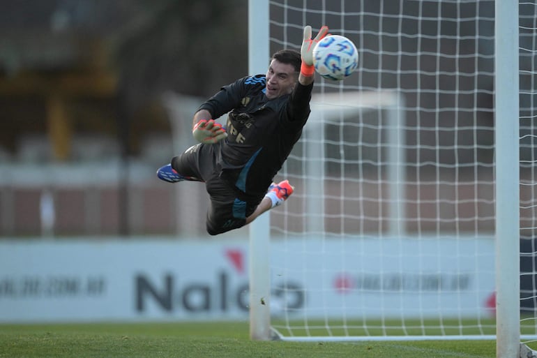 TOPSHOT - Argentina's national football team goalkeeper Emiliano Martinez stops a penalty during a training session in Ezeiza, Buenos Aires on September 3, 2024. Argentina will face Chile for the 2026 FIFA World Cup South American qualifiers on September 5 in Buenos Aires. (Photo by JUAN MABROMATA / AFP)