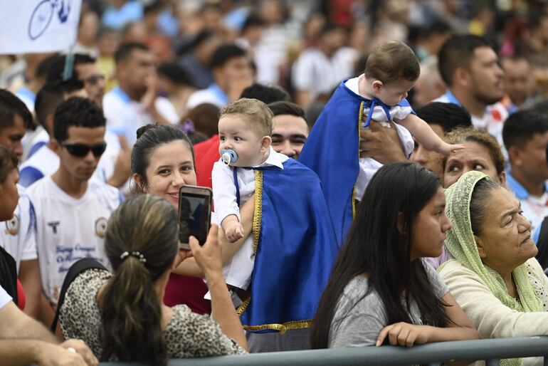 Eric y Ashley, mellizos, ayer se robaron la atención por su vestimenta alusiva a la Virgen de Caacupé durante la misa matinal.