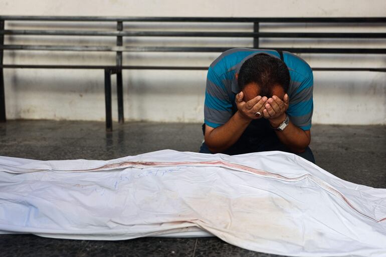 Un hombre llora junto al cuerpo del doctor Hani al-Jaafarawi, jefe de los equipos de ambulancias de Gaza, durante su funeral el pasado martes, luego de que este falleciera supuestamente en ataque aéreo israelí.