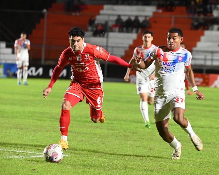 El jugador de Cerro Porteño, Diego León, intenta superar en velocidad al defensor de General Caballero JLM Miller Mareco.