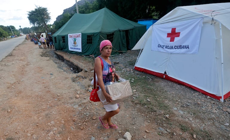 Una mujer lleva una caja de donaciones en un campamento de la Cruz Roja Cubana cerca del pueblo de San Antonio del Sur, provincia de Guantánamo, Cuba.