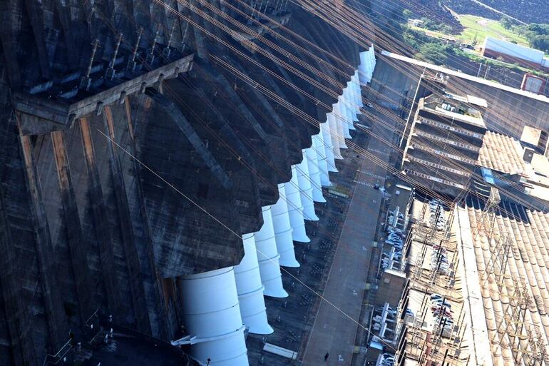 Represa de Itaipú, además de los 20 colosales tubos que descargan el agua del embalse sobre las turbinas, a la derecha se observa su Edificio de la Producción.