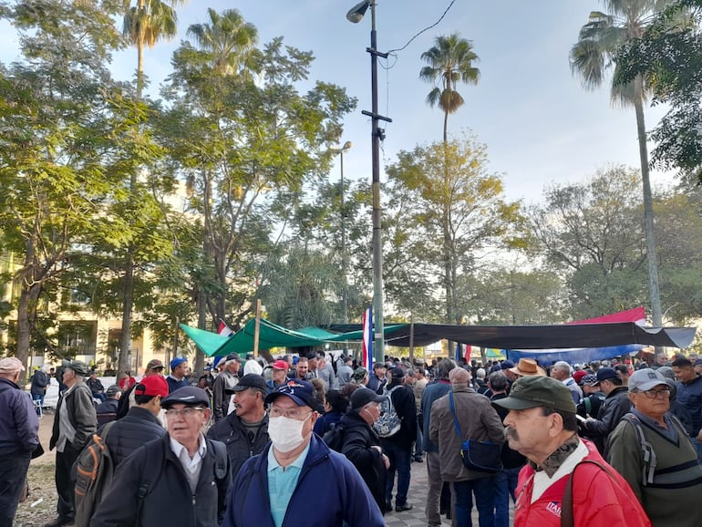 Ex obreros de Itaipú se  aglutinan en la plaza de Armas para seguir la sesión de Diputados.