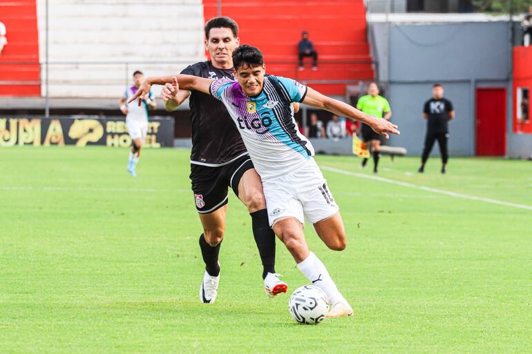 Lorenzo Melgarejo se lleva el balón ante la marca de Walter Rodríguez