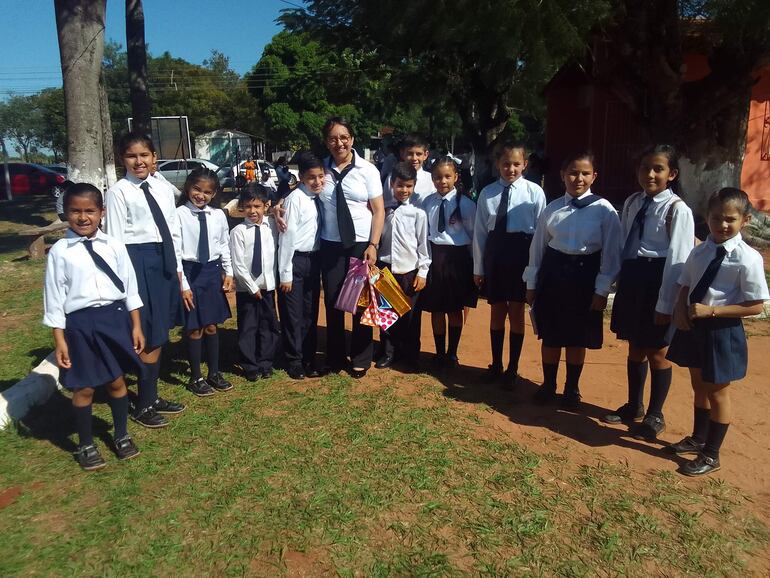 La docente posa en una foto con un grupo de alumnos de la institución educativa 