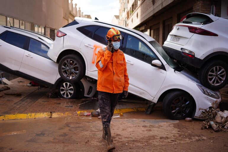 Un rescatista junto a automóviles dañados por la inundación en Sedavi, en la región española de Valenica, este domingo.