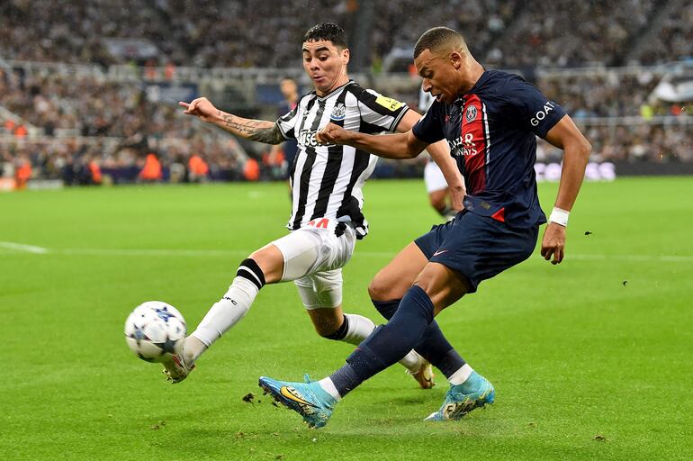 Miguel Almirón (i), futbolista del Newcastle, pelea por el balón con Kylian Mbappé, jugador del París Saint-Germain, en un partido del Grupo F de la Champions League.